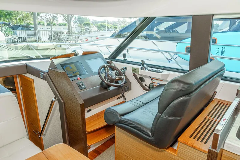 Slide: The Image of Interior helm of 2016 Tiara Yachts C44 Coupe with leather seating and navigation controls. - 27