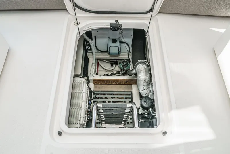 Slide: The Image of Engine compartment of 2016 Tiara Yachts C44 Coupe, showcasing mechanical components and access ladder. - 42