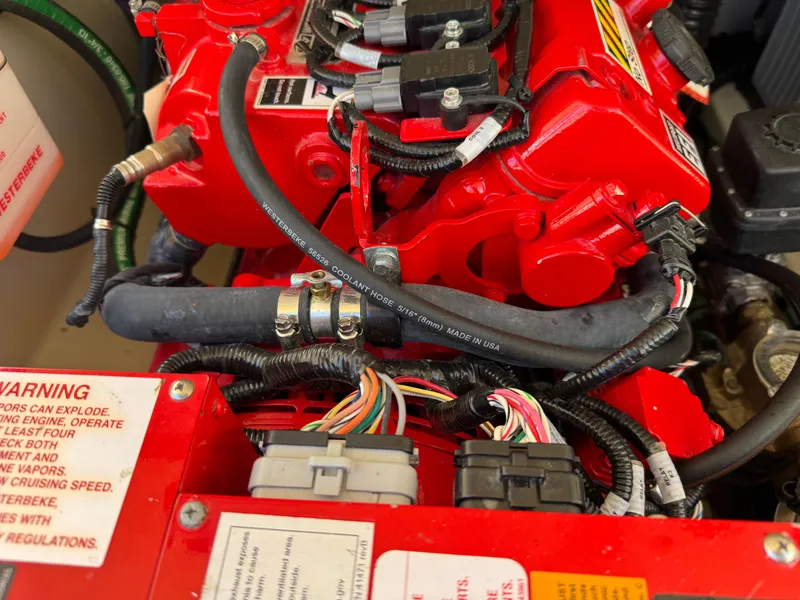 Slide: The Image of Engine compartment of 2023 Chris-Craft Calypso 35 with red components and wiring. - 11