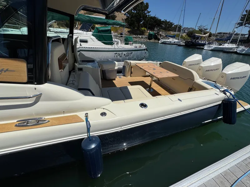 Slide: The Image of 2023 Chris-Craft Calypso 35 boat docked, featuring luxurious seating and powerful Mercury engines. - 17