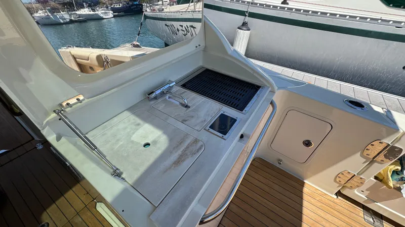 Slide: The Image of Outdoor kitchen area on a 2023 Chris-Craft Calypso 35 boat, featuring a sink and grill. - 37