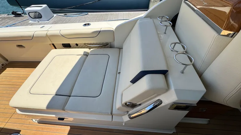 Slide: The Image of 2023 Chris-Craft Calypso 35 boat seating area with cup holders and wooden deck. - 38