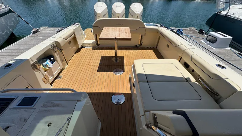 Slide: The Image of 2023 Chris-Craft Calypso 35 boat interior with teak flooring and seating area. - 39