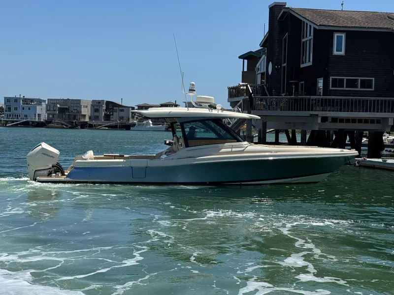 Slide: The Image of 2023 Chris-Craft Calypso 35 boat cruising near waterfront homes. - 8