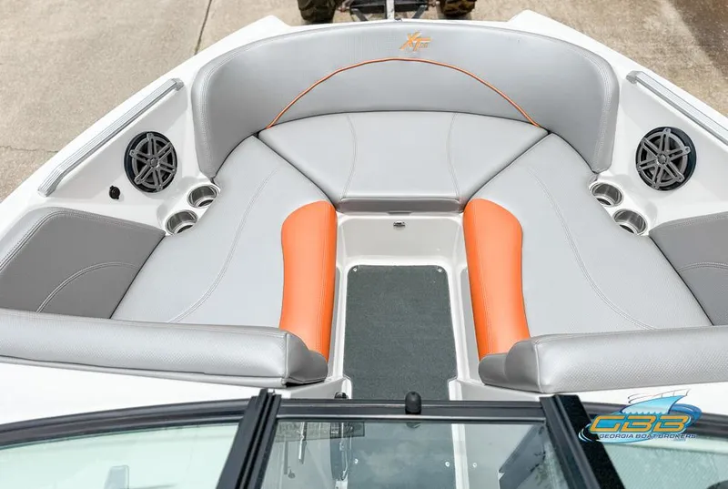Slide: The Image of 2017 MasterCraft XT20 boat interior with gray and orange seating, cup holders, and speakers. - 10