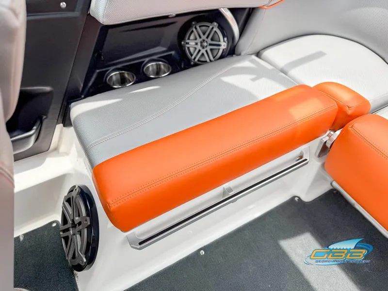 Slide: The Image of 2017 MasterCraft XT20 interior with orange and gray seating, cup holders, and speakers. - 13