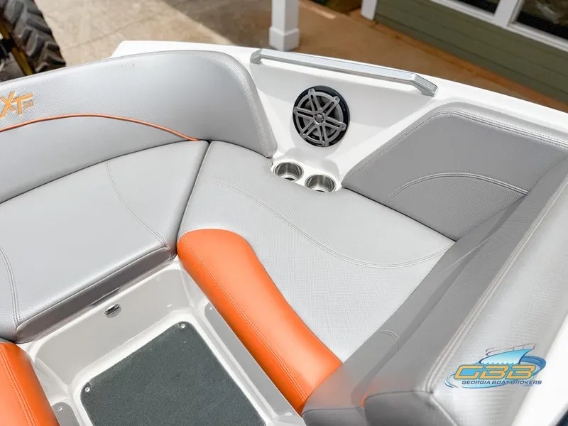 Slide: The Image of 2017 MasterCraft XT20 boat interior with gray and orange seating, speaker, and cup holders. - 14