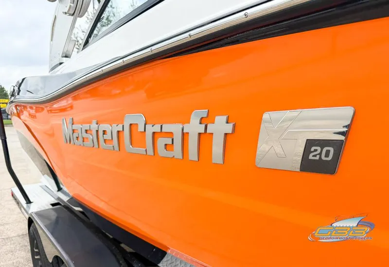 Slide: The Image of Orange 2017 MasterCraft XT20 boat with logo and branding. - 4
