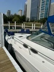 Slide: The Image of 2000 Sea Ray 310 Sundancer docked near city skyline. - 13