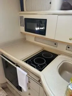 Slide: The Image of Compact kitchen in a 2000 Sea Ray 310 Sundancer yacht with stove, microwave, and sink. - 8