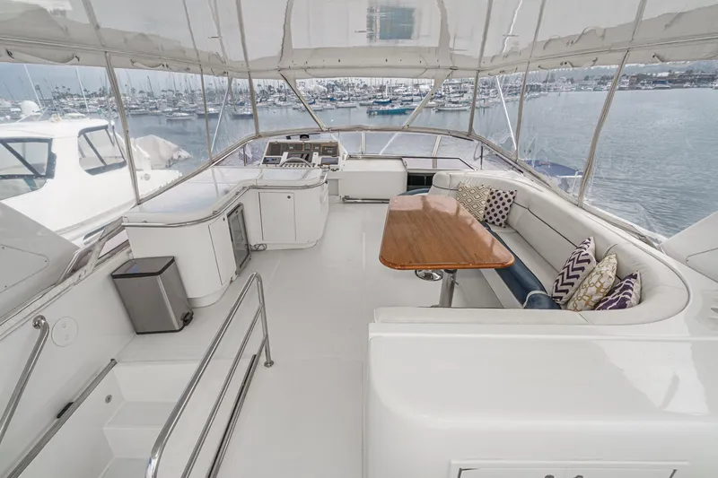 Slide: The Image of Spacious flybridge of 1999 Horizon 70 Motor Yacht with seating and table, overlooking marina. - 10