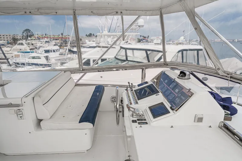 Slide: The Image of Interior view of 1999 Horizon 70 Motor Yacht helm with marina background. - 13