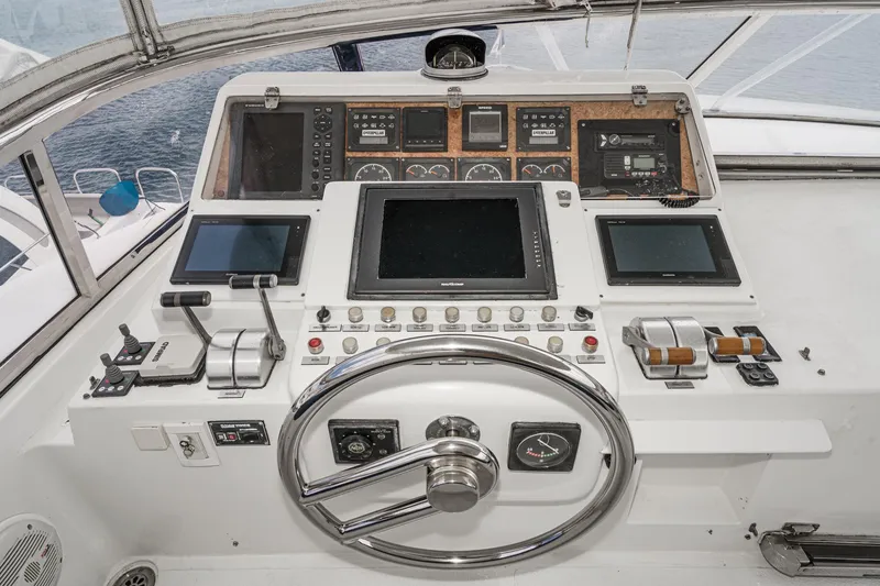 Slide: The Image of Control panel of a 1999 Horizon 70 Motor Yacht with navigation screens and steering wheel. - 15