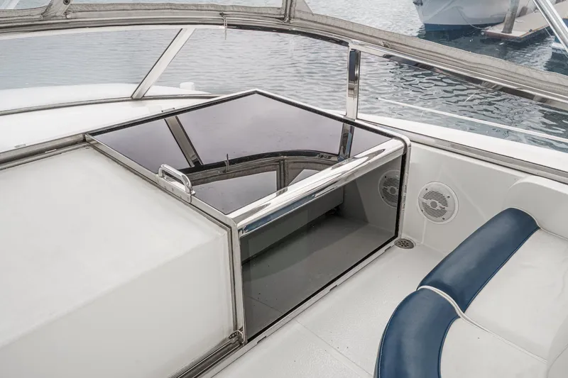 Slide: The Image of 1999 Horizon 70 Motor Yacht interior with seating and glass hatch, docked on calm water. - 16