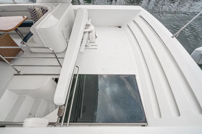 Slide: The Image of 1999 Horizon 70 Motor Yacht deck with seating, table, and water view. - 21