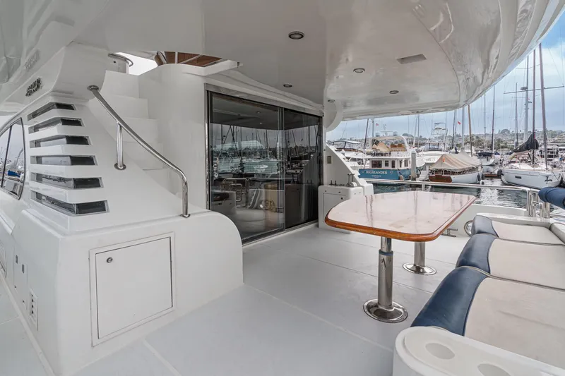 Slide: The Image of 1999 Horizon 70 Motor Yacht deck with seating, table, and marina view. - 23