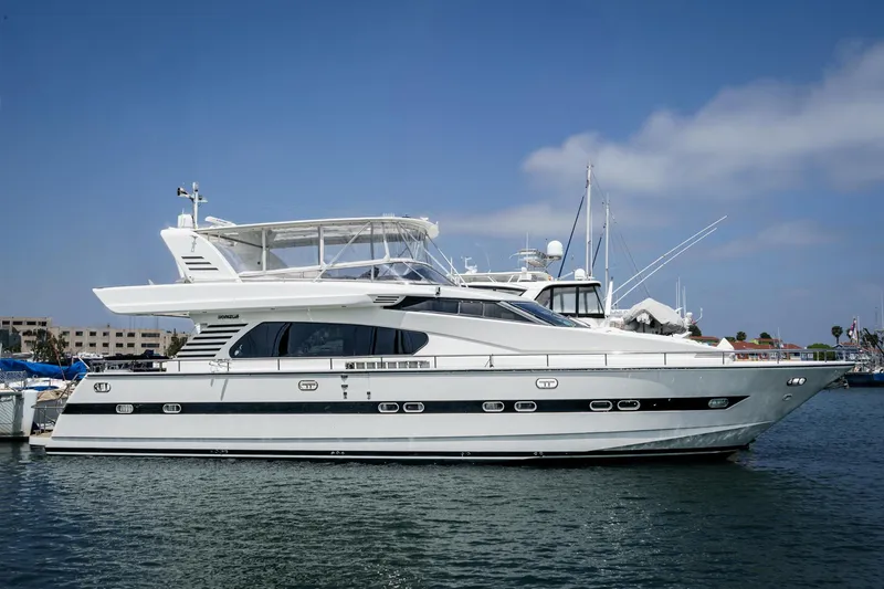 Slide: The Image of 1999 Horizon 70 Motor Yacht docked in a marina under a clear blue sky. - 5