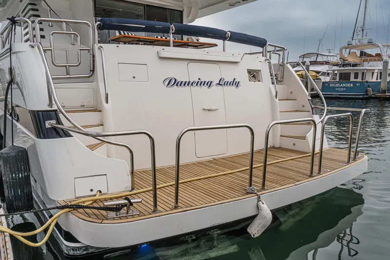 Slide: The Image of 1999 Horizon 70 Motor Yacht docked, featuring a spacious rear deck and elegant design. - 8