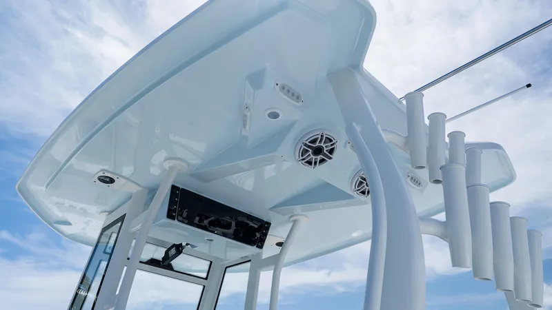 Slide: The Image of Tidewater 282CC Adventure 2026 boat top view with rod holders and speakers against blue sky. - 11