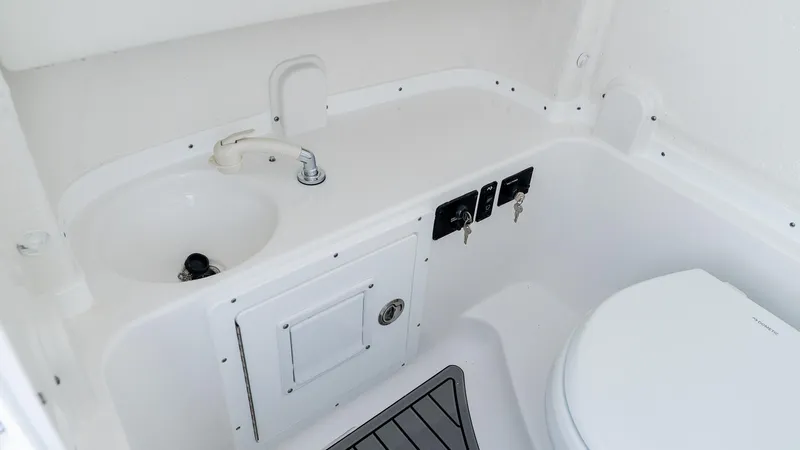 Slide: The Image of Interior of 2026 Tidewater 282CC Adventure boat featuring a compact bathroom setup. - 19