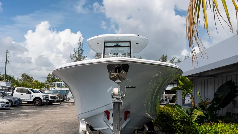 Slide: The Image of 2026 Tidewater 282CC Adventure boat on trailer, parked outdoors under cloudy sky. - 2