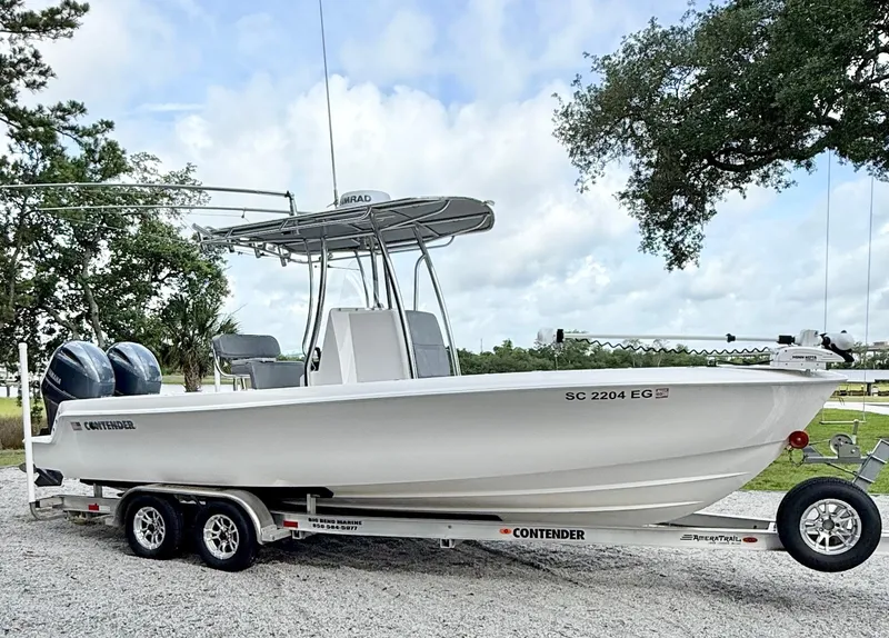 Slide: The Image of 2023 Contender 24 Sport boat on trailer, parked outdoors under cloudy sky. - 7