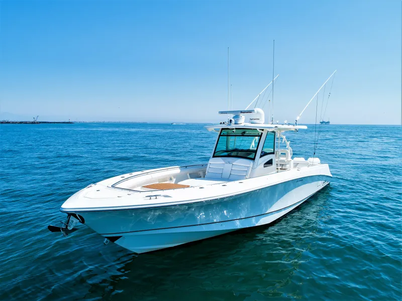 The Image of 2014 Boston Whaler 370 Outrage boat on open sea under clear blue sky. - 0