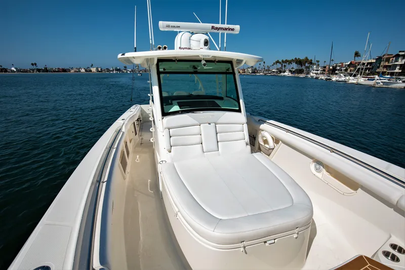 Slide: The Image of 2014 Boston Whaler 370 Outrage boat on calm water, featuring spacious deck and seating. - 10