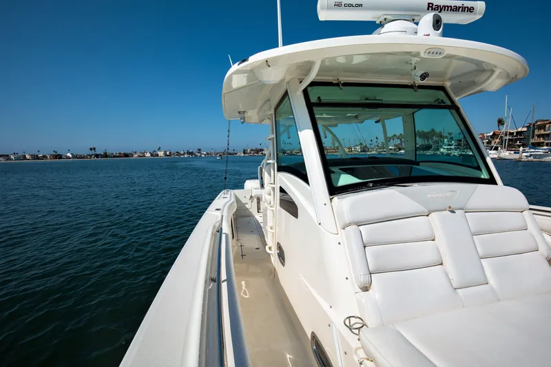 Slide: The Image of 2014 Boston Whaler 370 Outrage boat on calm water, clear sky, marina in background. - 11