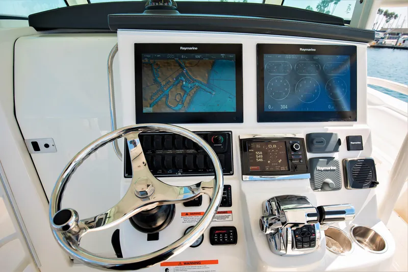 Slide: The Image of Boston Whaler 370 Outrage 2014 helm with dual Raymarine displays and controls. - 13