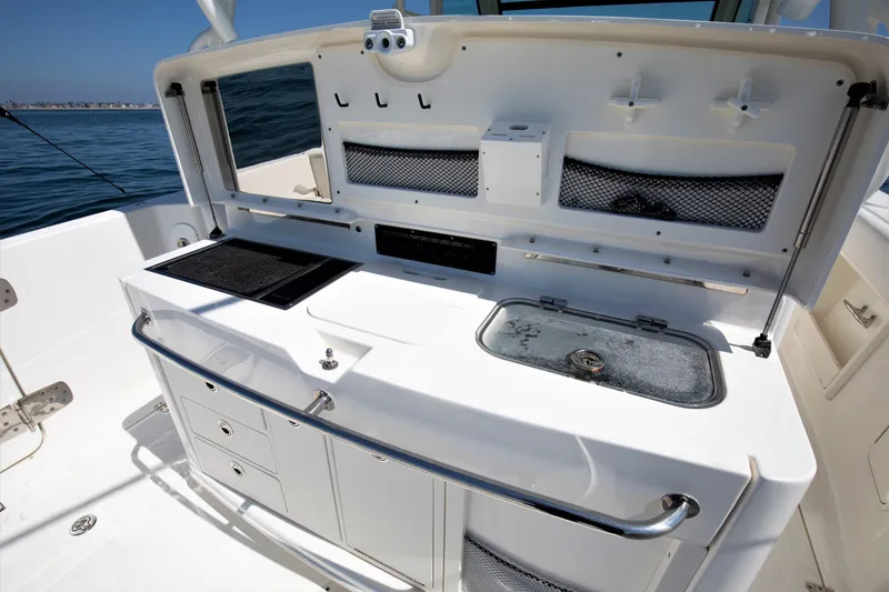 Slide: The Image of 2014 Boston Whaler 370 Outrage boat interior with fishing station and storage compartments. - 14