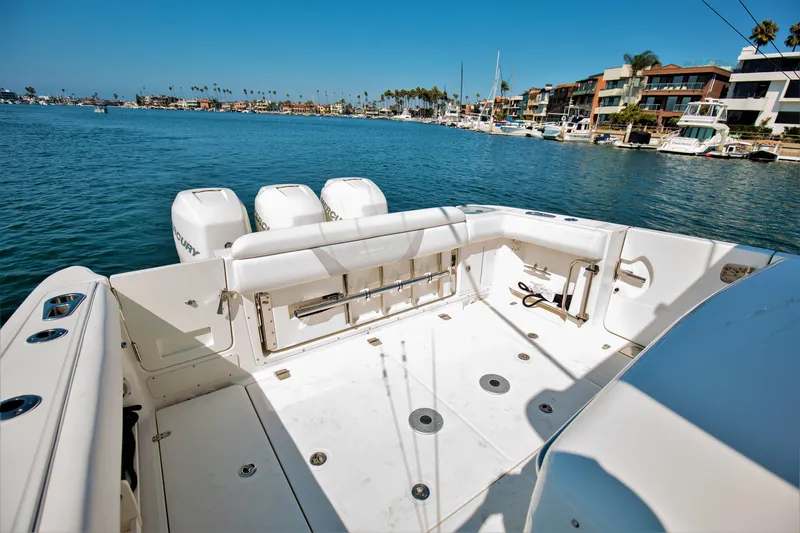 Slide: The Image of 2014 Boston Whaler 370 Outrage boat with spacious deck, docked in a scenic marina. - 17