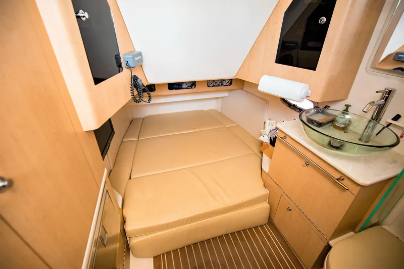Slide: The Image of 2014 Boston Whaler 370 Outrage cabin interior with beige seating and modern amenities. - 20
