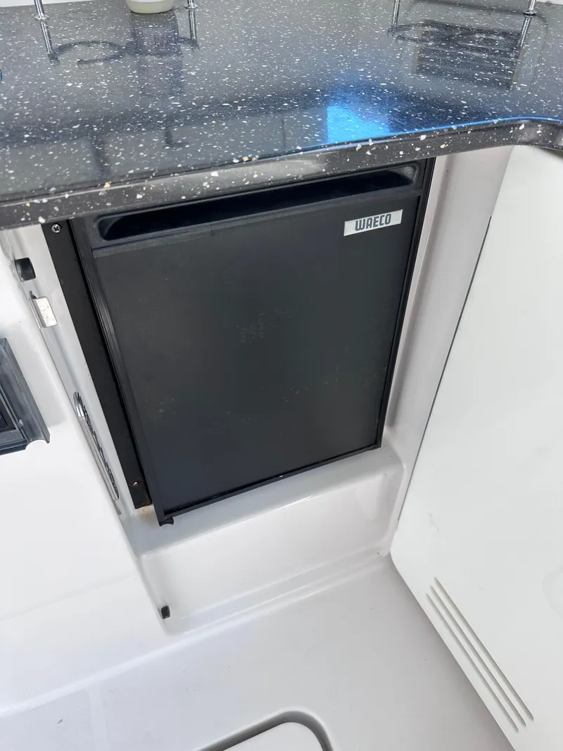 Slide: The Image of Compact fridge in 2008 Four Winns V458 boat with speckled countertop. - 10