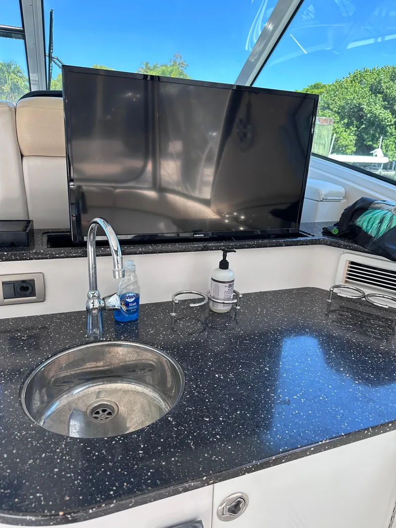 Slide: The Image of Luxury yacht interior with sink, countertop, and TV on a 2008 Four Winns V458. - 13