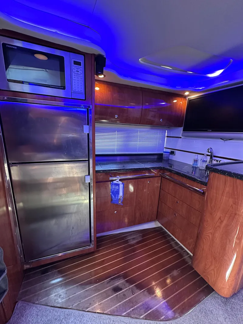 Slide: The Image of Luxurious 2008 Four Winns V458 yacht kitchen with modern appliances and ambient lighting. - 21