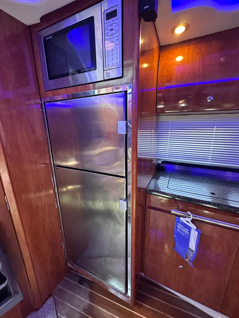 Slide: The Image of 2008 Four Winns V458 yacht kitchen with stainless steel appliances and wood cabinetry. - 23