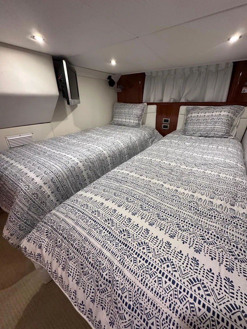 Slide: The Image of 2008 Four Winns V458 cabin with twin beds and patterned bedding. - 29
