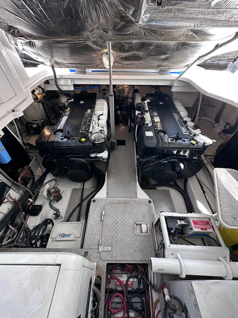 Slide: The Image of Engine room of a 2008 Four Winns V458 boat, featuring dual engines and mechanical components. - 34
