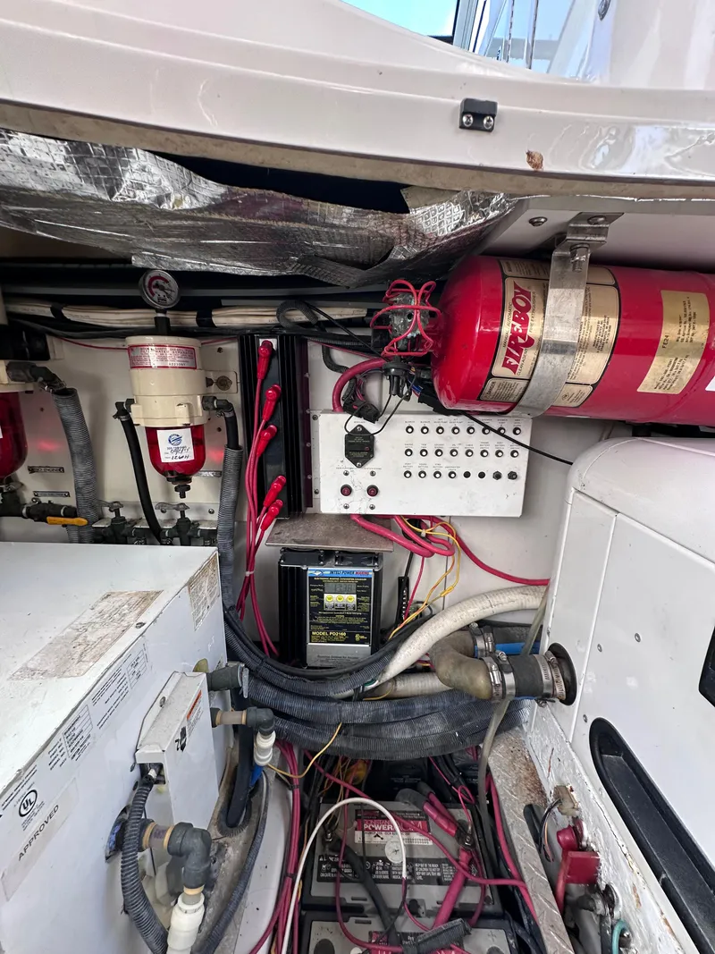 Slide: The Image of Engine compartment of 2008 Four Winns V458 boat, featuring wiring, fire extinguisher, and control panel. - 42