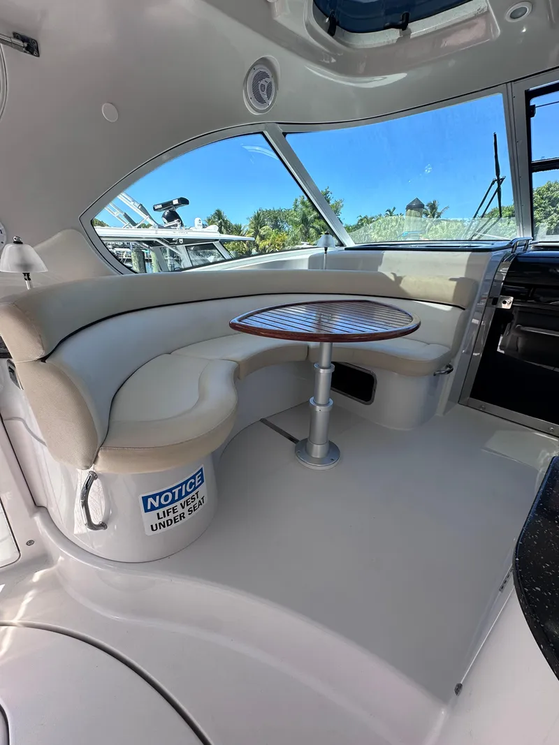 Slide: The Image of Interior of 2008 Four Winns V458 yacht with curved seating and wooden table. - 5