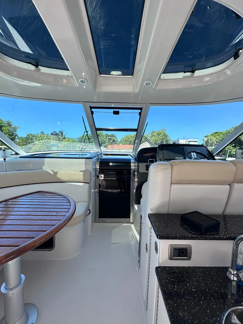 Slide: The Image of Interior of 2008 Four Winns V458 yacht with seating, table, and helm under skylight. - 6