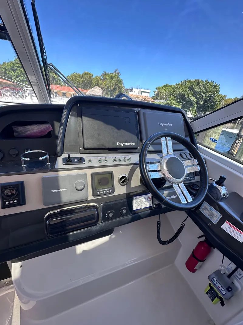 Slide: The Image of 2008 Four Winns V458 boat helm with Raymarine navigation system and steering wheel. - 8