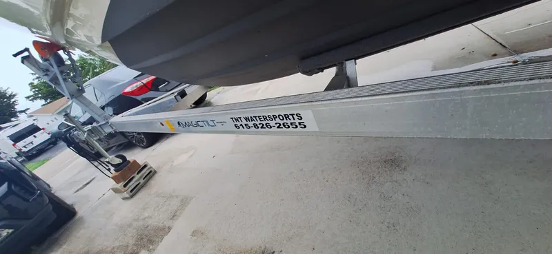 Slide: The Image of 2022 Scout 215 XSF boat on trailer, parked in driveway, with visible contact information. - 18