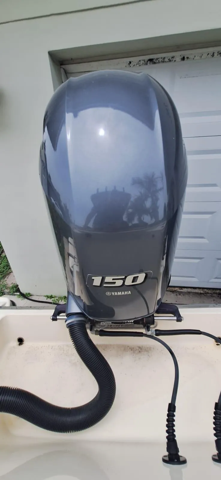 Slide: The Image of Yamaha 150 outboard motor on 2022 Scout 215 XSF boat, parked near a garage. - 21