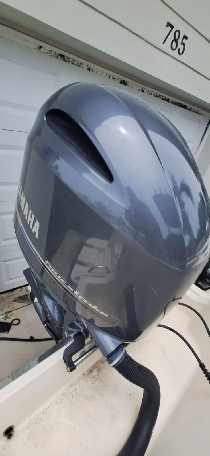 Slide: The Image of 2022 Scout 215 XSF with Yamaha outboard motor, parked near garage. - 22