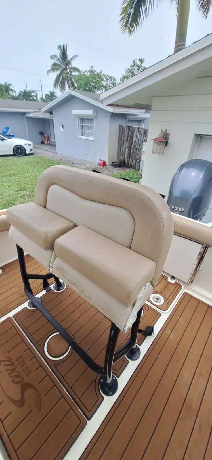 Slide: The Image of 2022 Scout 215 XSF boat interior with cushioned seating and teak flooring. - 6