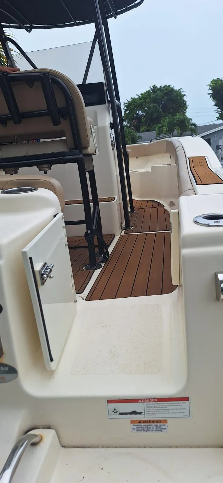 Slide: The Image of 2022 Scout 215 XSF boat interior with teak flooring and seating area. - 7