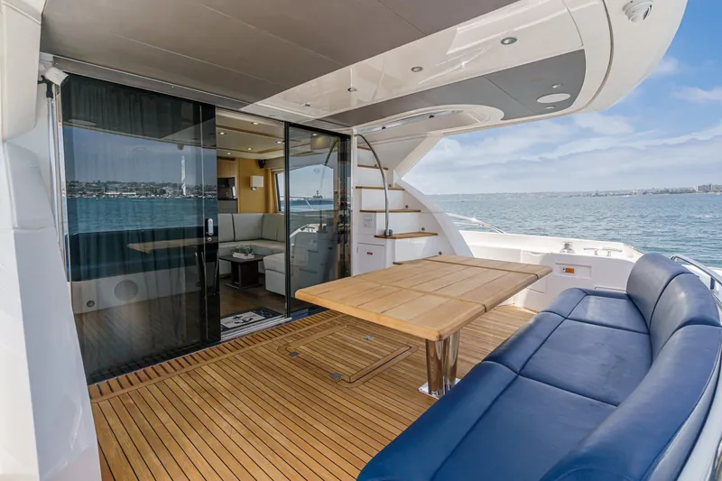 Slide: The Image of Luxurious 2017 Sunseeker Manhattan 65 yacht deck with seating, table, and ocean view. - 12