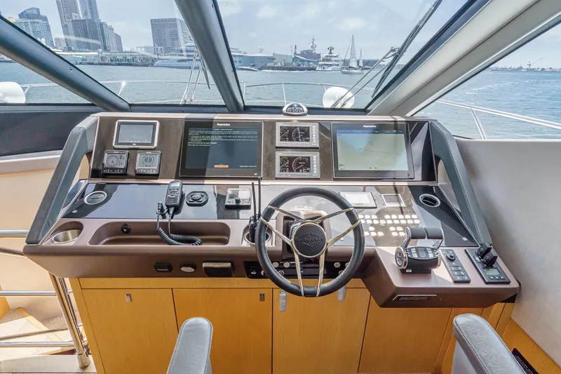 Slide: The Image of 2017 Sunseeker Manhattan 65 yacht helm with modern navigation equipment and city skyline view. - 28